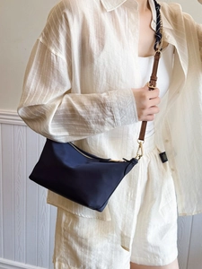 Navy blue canvas crossbody bag with brown adjustable strap in minimalist fashion style