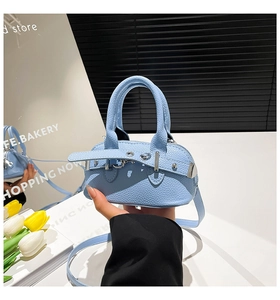 Detailed macro view of light blue lychee pattern leather handbag with silver metal hardware