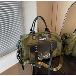 Detail of army green nylon travel bag with NOCO patches and crossbody strap