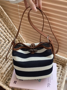 Blue and white striped raffia bucket bag with brown leather strap and olive button