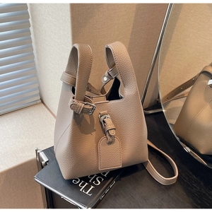 Détail du sac seau en cuir grainé kaki avec boucles en argent et bandoulière réglable