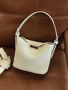 Off-white hand-woven bucket bag with wooden buckle and detachable shoulder strap