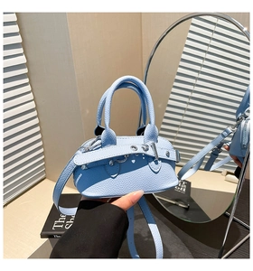 Detail of light blue shell bag showing litchi texture leather and silver hardware