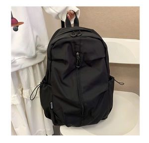 Detail of durable nylon backpack with side buckle and brand logo held by a model