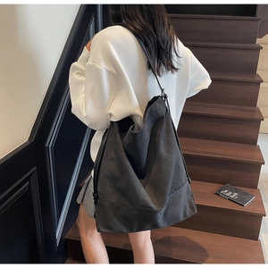 Detail of minimalist black canvas bucket bag showing slouchy texture and large capacity