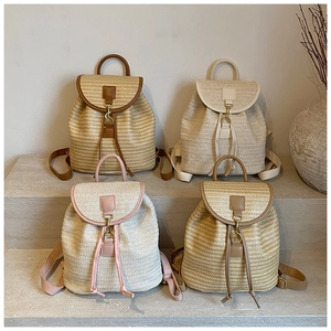 Detail showing four straw woven backpacks in different colors with metal buckle closure