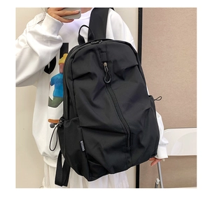 Side view of black large capacity travel backpack on model with matte nylon texture