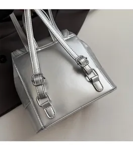 Detail of silver metallic backpack featuring high-quality polished metal buckles and straps