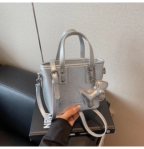 Détail du sac seau en cuir PU argenté avec lettrage de mode et pendentif en forme de chien