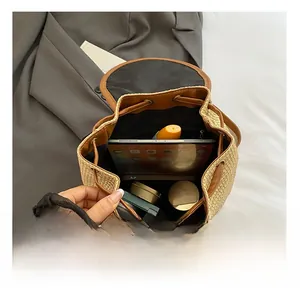 Interior view showing the large capacity of a straw drawstring backpack with a tablet