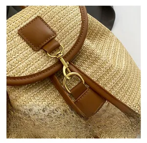 Detailed close-up of straw backpack featuring retro gold hardware and brown leather trim