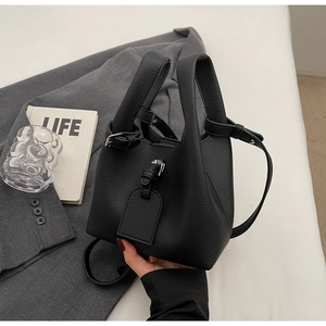 Détail du sac seau noir en cuir grainé avec finitions argentées et bandoulière
