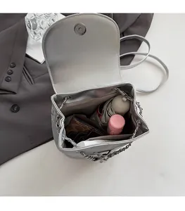 Spacious interior of silver chain bucket bag showing storage for makeup and wallet