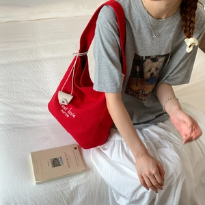 Detail of red canvas tote bag with C'est la vie text and drawcord pendant