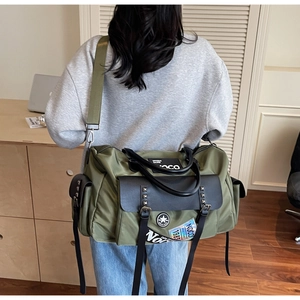 Detail of olive green canvas bag with leather flap and rivet accents shown in use