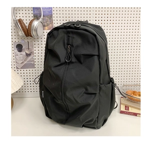 Detail of black nylon backpack featuring wide opening and vertical zipper pocket design