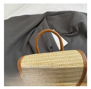 Detail showing woven straw texture and premium brown leather handle on casual backpack
