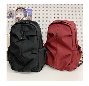 Detail view of large capacity nylon backpacks with vertical zippers in black and dark red