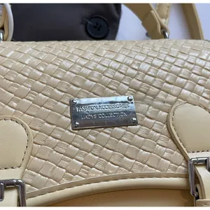 Détail du sac à dos tressé beige avec logo en métal argenté et boucle élégante