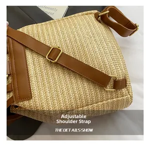 Detailed close-up of adjustable brown leather shoulder strap on straw backpack