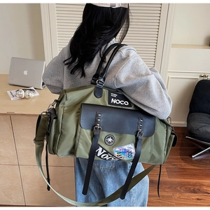 Olive green canvas travel bag featuring black leather flap with decorative silver rivets