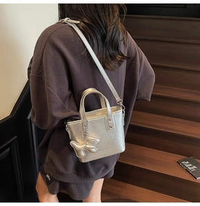 Gros plan d'un sac seau argenté froissé avec un porte-clé animal sur un escalier