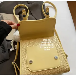 Gros plan sur la fermeture magnétique et la texture tissée du sac à dos jaune chic