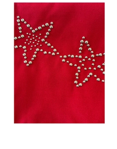 Detail of silver metallic studs forming a star pattern on red canvas tote bag fabric