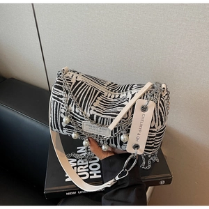 Detail of canvas pillow bag with zebra stripes, silver chain and pearl charms