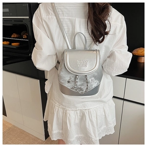 Detail showing the silver metallic backpack texture and decorative metal chain on the back
