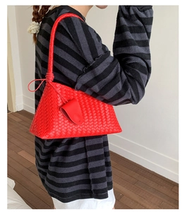 Detail of red woven leather shoulder bag showing the intricate Intrecciato craftsmanship