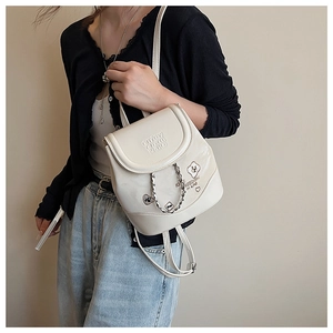 Detail of off-white mini backpack with silver chain and freedom in life patch