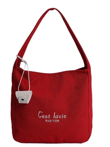 Minimalist red canvas tote bag with white text print and small beige hanging pouch