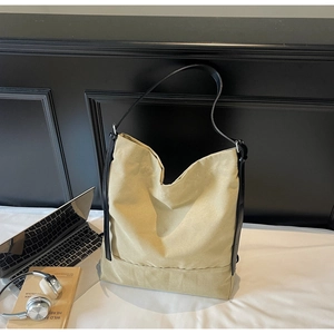 Spacious beige canvas tote bag shown with a laptop and books for a casual lifestyle look