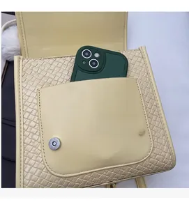 Détail du sac à dos beige minimaliste avec texture tissée et poche avant magnétique pratique