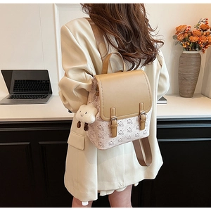 Détail d'un sac à dos kaki et crème avec imprimés d'ours et pendentif nuage doux