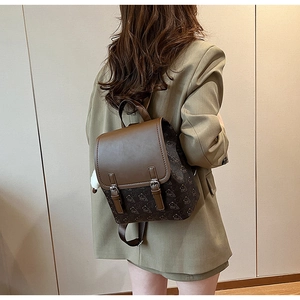 Détail d'un sac à dos vintage en cuir marron avec motif d'ours et sangles décoratives