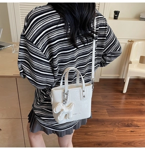 Sac seau en cuir grainé blanc crème avec breloque chien porté en sac bandoulière chic