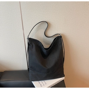 Detail der großen schwarzen Canvas-Tasche mit breitem Boden und silberner Metallschnalle