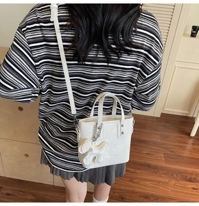 Détail du mini sac seau blanc avec texture litchi et accessoire de charme chiot