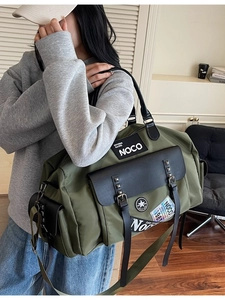 Army green large capacity canvas travel bag with retro badges shown on a model