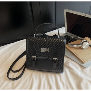 Vue détaillée d'un sac à dos tissé noir avec boucles argentées et un ordinateur portable
