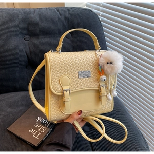 Gros plan d'un sac à dos jaune à texture tissée avec un charmant monstre en peluche