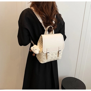 Détail du sac à dos crème avec imprimé ours et breloque nuage mignonne sur le côté