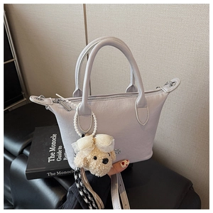 Détail du sac seau lilas en similicuir avec un charmant pendentif d'ours blanc