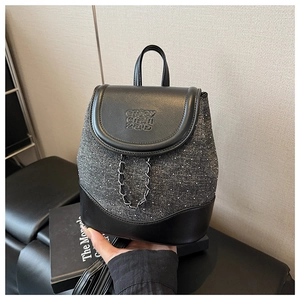 Detail view of the mini backpack featuring black leather trim and grey textured fabric