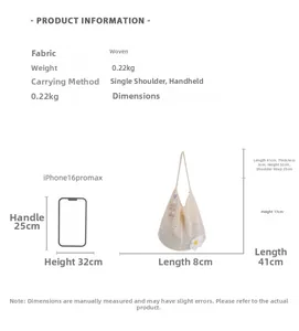 Größenvergleich der beigen Stricktasche mit Gänseblümchen neben einem Smartphone