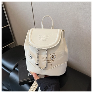 Close-up of white glossy backpack with cartoon embroidery and silver metal chain detail