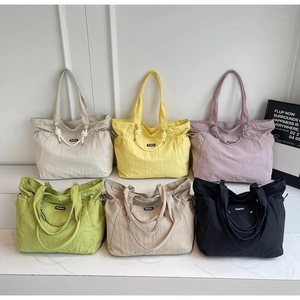 Six colorful nylon tote bags in beige, yellow, purple, green, khaki, and black finishes
