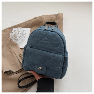 Detail of blue denim mini backpack with diamond quilting and metal twist lock